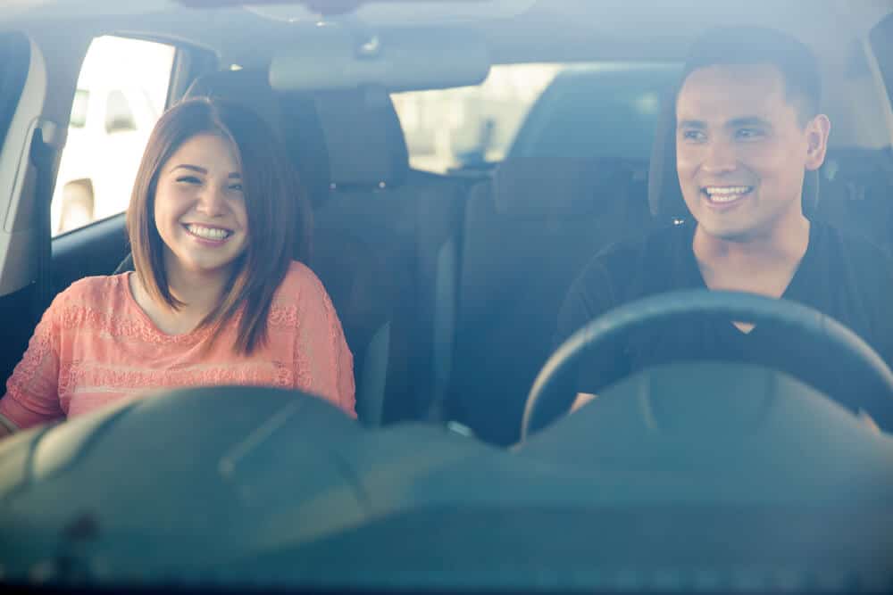 hombre y mujer en auto sonriendo