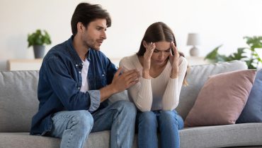 Pareja preocupada buscando seguro médico.