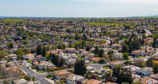 La ciudad de Antioch, California, en un hermoso día soleado con verdes colinas, calles, casas y autos.