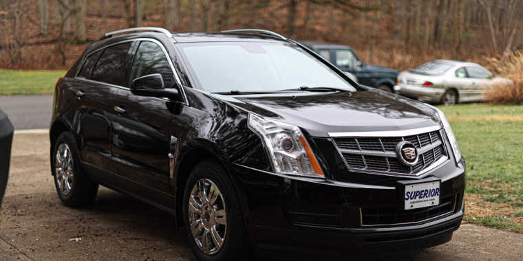 AlCadillac SRX negra estacionada en una tarde de otoño. 