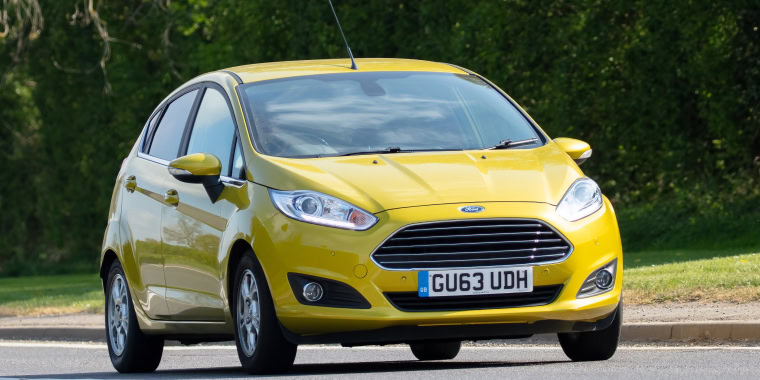 Ford Fiesta amarillo avanzando en la carretera.